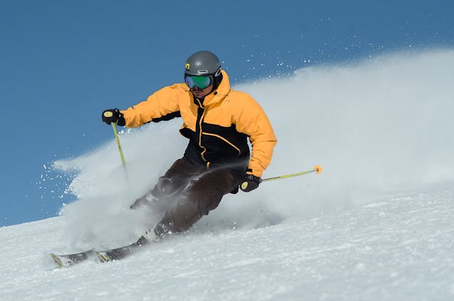 Homem esquiando por uma ladeira nevada em Trysil, Noruega, cercada por vistas panorâmicas da montanha e ar nítido de inverno.